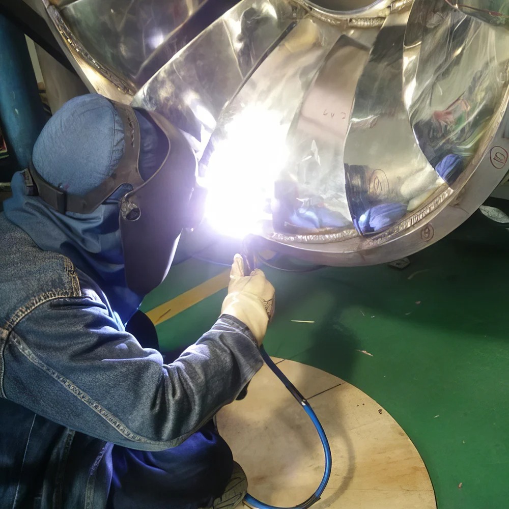 JPE technician performing precision weld on marine propeller
